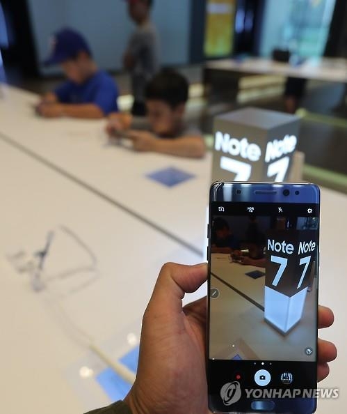 A customer holds a Galaxy Note 7 at Samsung Electronics Co.'s exhibition room at its main office in southern Seoul on Sept. 2, 2016, as the tech giant announced a global recall of the phablet after several devices caught fire while being charged. (Yonhap)
