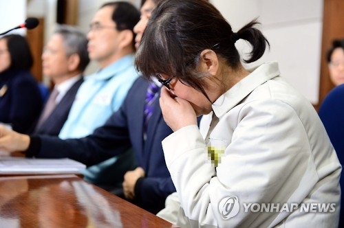 Choi Soon-sil, a longtime friend of President Park Geun-hye who has been indicted on charges of abuse of power and attempted fraud, covers her mouth during her trial at the Seoul Central District Court on Jan. 17, 2017, over an influence-peddling scandal that has led to the president's impeachment. (Pool photo) (Yonhap)