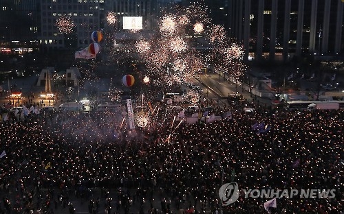 South Korean protesters watch a firwork display at Gwanghwamun Square in Seoul on March 11, 2017, one day after the Constitutional Court's ruling to uphold the impeachment of President Park Geun-hye. (Yonhap) 