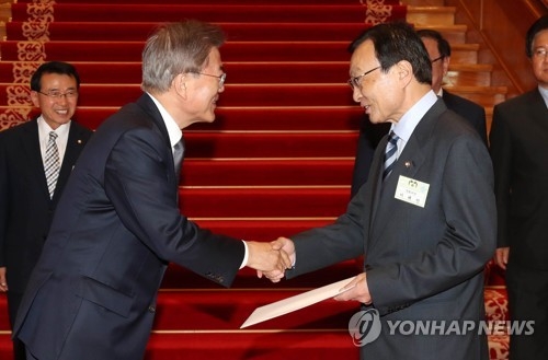 President Moon Jae-in (L) shakes hands with his special envoy to China, Lee Hae-chan, at Cheong Wa Dae in Seoul on May 16, 2017, after handing over his personal letter to Chinese President Xi Jinping. (Courtesy of Cheong Wa Dae) (Yonhap)