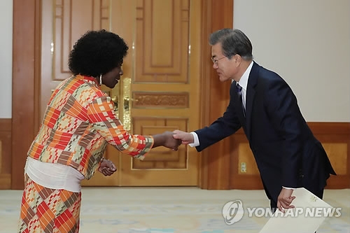 President Moon Jae-in (R) shakes hands with Difie Agyarko Kusi, Ghana's new ambassador to Seoul, after being presented with her credentials in a ceremony held at his presidential office Cheong Wa Dae on Nov. 2, 2017. (Yonhap)
