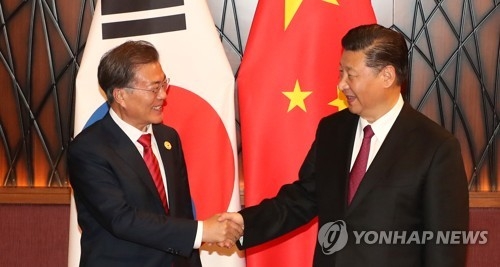 South Korean President Moon Jae-in (L) and Chinese President Xi Jinping shake hands before the start of their bilateral summit on the sidelines of the Asia-Pacific Economic Cooperation forum in Danang, Vietnam on Nov. 11, 2017. (Yonhap)