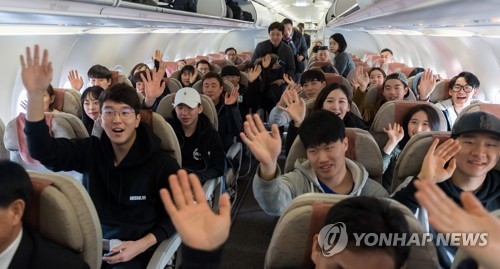In this Joint Press Corps photo, South Korean skiers wave onboard a plane bound for North Korea on Jan. 31, 2018. (Yonhap)