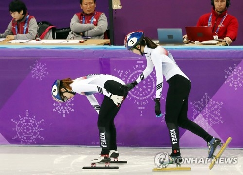 South Korean short track speed skater Shim Suk-hee (R) checks on her teammate Choi Min-jeong after both fell and crashed into the safety padding during the women's 1,000-meter final at the PyeongChang Winter Olympics at Gangneung Ice Arena in Gangneung, Gangwon Province, on Feb. 22, 2018. (Yonhap)