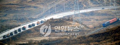 This file photo taken in 2007 shows an inter-Korean cargo train and a convoy of trucks crossing the border. (Yonhap)