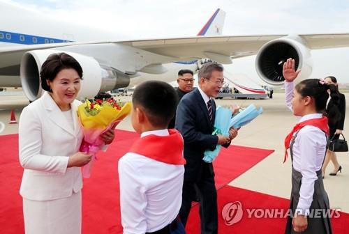 South Korean President Moon Jae-in (2nd from R) and his wife Kim Jung-sook (L) receive flowers from North Korean children in a welcoming ceremony at Pyongyang's airport in this pool photo taken on Sept. 18, 2018. (Yonhap)