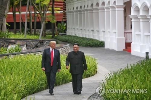 U.S. President Donald Trump (L) takes a walk with North Korean leader Kim Jong-un at the Capella Hotel in Singapore on June 12, 2018, after a luncheon meeting in this photo provided by Singapore's Ministry of Communications and Information. (Yonhap file photo) 