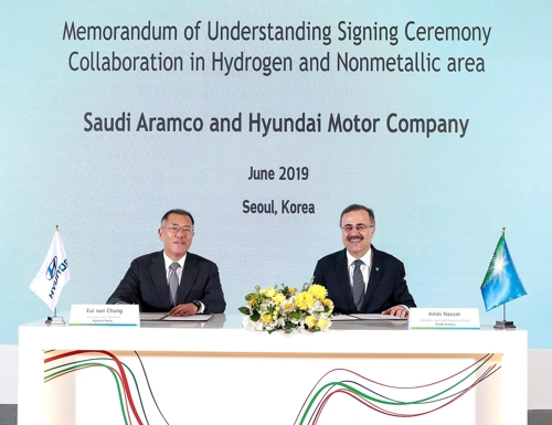 In this photo taken on June 25, 2019, and provided by Hyundai Motor, Hyundai Motor Executive Vice Chairman Chung Euisun (L) and Ahmad A. Al-Sa'adi, senior vice president of technical services at Saudi Aramco, pose for a photo after signing an MOU to cooperate on hydrogen energy in Seoul. (PHOTO NOT FOR SALE) (Yonhap)