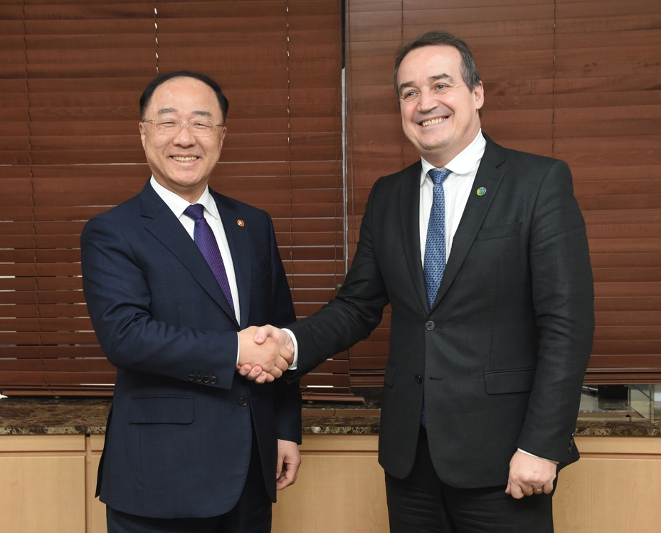 South Korean Finance Minister Hong Nam-ki (L) shakes hands with Yannick Glemarec, executive director of the U.N. Green Climate Fund, at the government complex building in central Seoul on Oct. 10, 2019, in this photo provided by the ministry. (PHOTO NOT FOR SALE) (Yonhap)