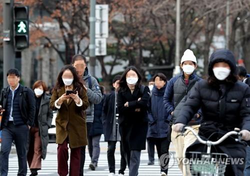 People wearing masks cross a road on their morning commute in Seoul amid the spread of a new coronavirus in this file photo taken Jan. 29, 2020. (Yonhap)