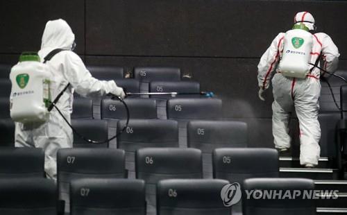 In this photo taken on Feb. 26, 2020, quarantine officials disinfect a movie theater in Seoul known to have been visited by a person diagnosed with COVID-19. (Yonhap)