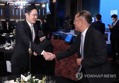 Samsung Group Vice Chairman Lee Jae-yong (L) shakes hands with Hyundai Motor Group Executive Vice Chairman Chung Euisun at a meeting for the new year in Seoul on Jan. 2, 2020. (Yonhap) 