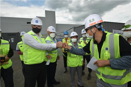 In this photo taken July 1, 2020, and provided by GM Korea, GM Korea President and CEO Kaher Kazem (L) bumps fists with an employee in the carmaker's plant in Changwon amid the coronavirus outbreak. (PHOTO NOT FOR SALE) (Yonhap) 