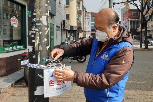 Seo In-young, a resident of Ilsan, northwest of Seoul, checks a hand sanitizer bottle in his neighborhood in this photo provided by Seo. (PHOTO NOT FOR SALE) (Yonhap)