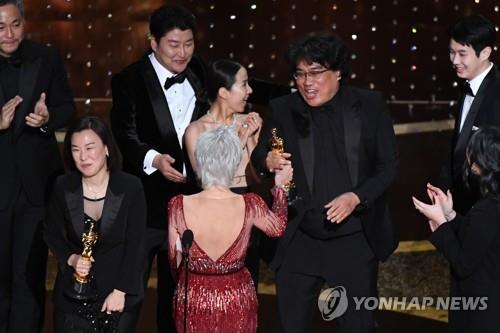 In this file photo released by AFP, "Parasite" director Bong Joon-ho (2nd from R) accepts the best picture award for the film during the 92nd Oscars at the Dolby Theatre in Los Angeles on Feb. 9, 2020. (PHOTO NOT FOR SALE) (Yonhap)