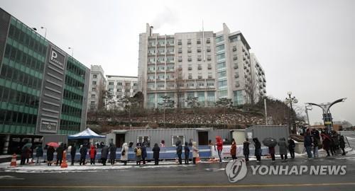 People stand in a line to take coronavirus tests at Hanyang University Hospital in eastern Seoul on Jan. 30, 2021, after a cluster of infections occurred at the hospital. (Yonhap)