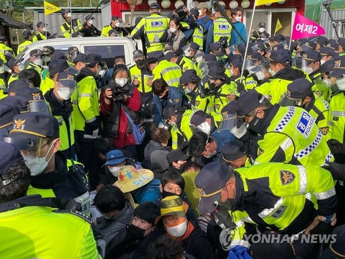 Police attempt to disperse protesters opposed to the delivery of construction equipment onto a THAAD base in Seongju, central South Korea, on April 28, 2021. (Yonhap)