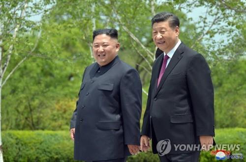 Chinese President Xi Jinping (R) and North Korean leader Kim Jong-un take a walk at the Kumsusan State Guesthouse in Pyongyang on June 21, 2019, in this photo released by the North's official Korean Central News Agency. (For Use Only in the Republic of Korea. No Redistribution) (Yonhap)