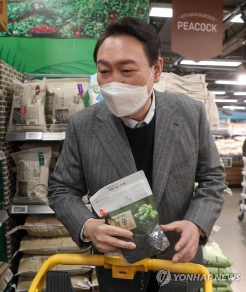 Yoon Suk-yeol, the presidential nominee of the main opposition People Power Party, buys beans at an Emart in Seoul on Jan. 8, 2022, in this photo provided by his campaign. (PHOTO NOT FOR SALE) (Yonhap)