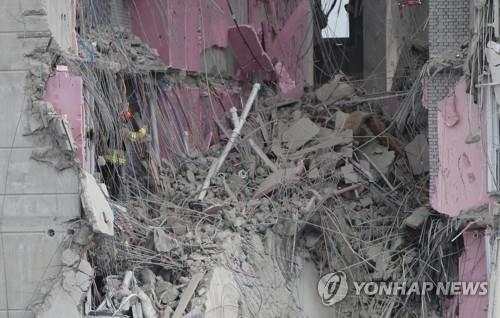 Rescuers comb through debris on Jan. 13, 2022, looking for workers who went missing in a deadly apartment construction accident in the southern city of Gwangju. (Yonhap)