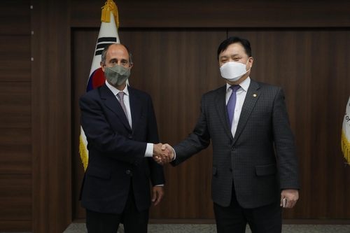 Vice Unification Minister Choi Young-jun (R) shakes hands with Tomas Ojea Quintana, U.N. special rapporteur on North Korea's human rights situation, during a meeting in Seoul on Feb. 16, 2022, in this photo provided by his office. (PHOTO NOT FOR SALE) (Yonhap)