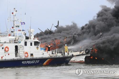 Firefighters work to put out a fire on fishing boats at Jeju Island's Hallim Port on July 7, 2022. (Yonhap)