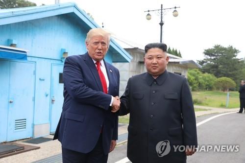 U.S. President Donald Trump (L) and North Korean leader Kim Jong-un shake hands at the inter-Korean border truce village of Panmunjom on June 30, 2019. (Yonhap)