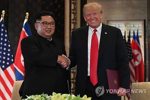 This AFP photo shows then U.S. President Donald Trump (R) shaking hands with North Korean leader Kim Jong-un after signing a joint statement at the Capella Hotel on Sentosa Island in Singapore on June 12, 2018. (Yonhap)
