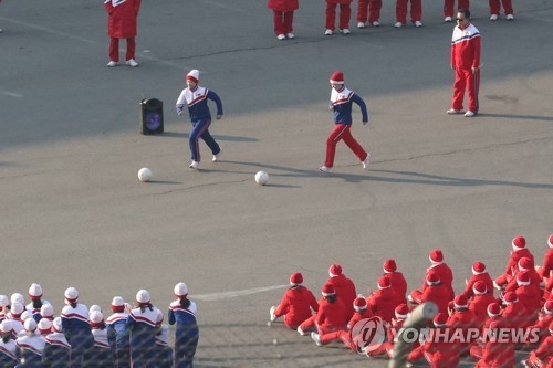 ボールを蹴りながら競争する北朝鮮応援団のメンバー＝１６日、麟蹄（聯合ニュース）