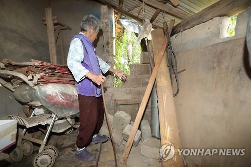 무너진 담벼락 살펴보는 주민