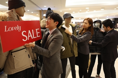 겨울 세일 상품을 진열하는 롯데백화점 직원들