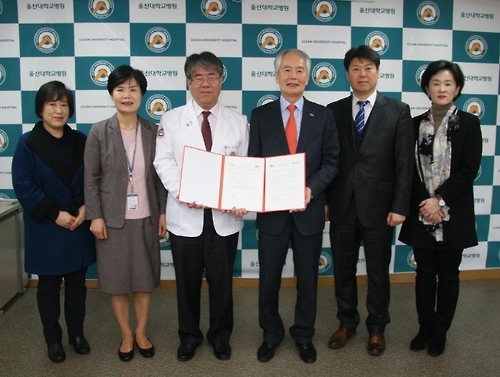 정융기 울산대병원장(가운데 왼쪽)과 부구욱 양산대총장이 협약서를 교환하고 있다.