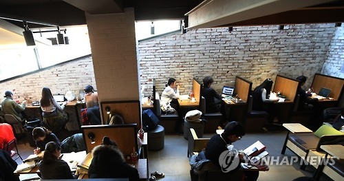 서울 할리스 커피 매장에서 손님들이 1인용 테이블에 앉아 있다. 할리스는 최근 1인 고객을 위해 주요 매장에 1인 좌석 및 도서관 형태의 분리형 좌석을 설치했다.[연합뉴스 자료사진]