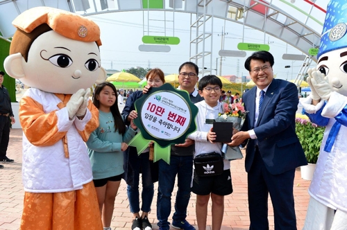10만번째 입장객인 강대규(가운데)씨 가족이 이근규(오른쪽) 제천시장과 기념촬영을 하고 있다.