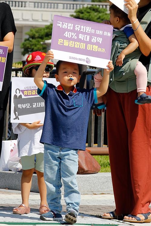 '내일 유치원 갈 수 있나요?'(서울=연합뉴스) 조현후 인턴기자 = 18일 오전 서울 청와대 분수대 앞에서 열린 '정부-한유총 졸속합의 우려 기자회견' 에서 '정치하는 엄마들' 소속 회원이 유아교육, 보육 정상화를 위한 3대 요구안으로 국공립 확대, 사립 공공성 강화, 당사자 참여보장을 발언하는 가운데 아이가 피켓을 들고 서 있다.