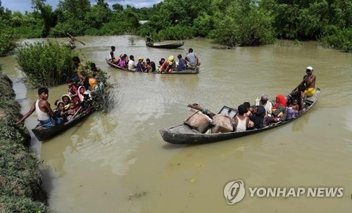 위태롭게 강을 건너는 난민들[AFP=연합뉴스 자료사진]