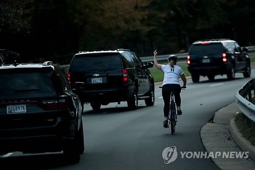 트럼프 차량에 '손가락 욕설' 날리는 자전거 여성