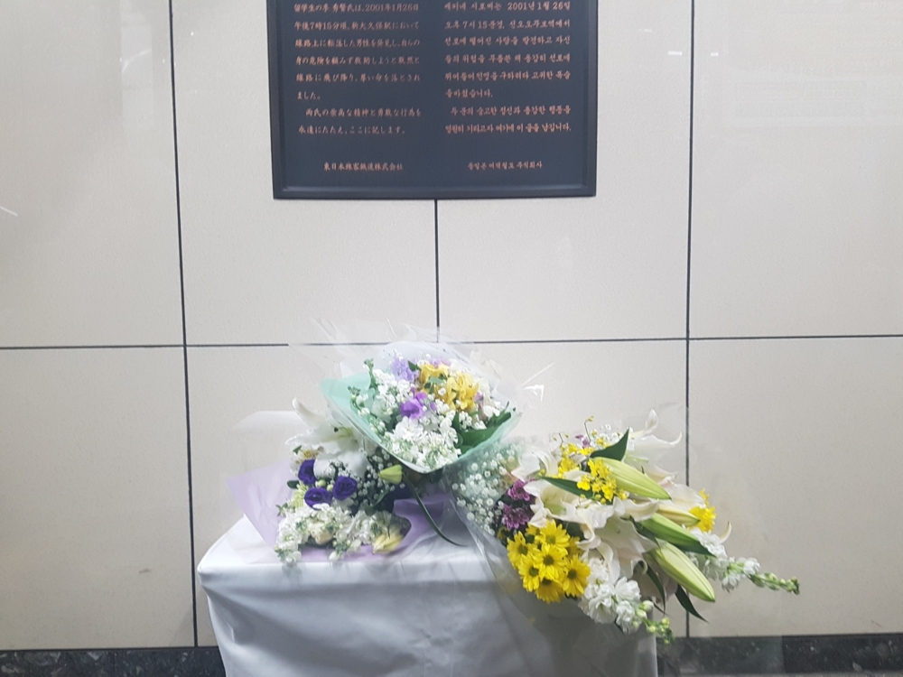 고인을 추모하는 글이 적힌 기림판 앞의 헌화대에 놓인 꽃들 