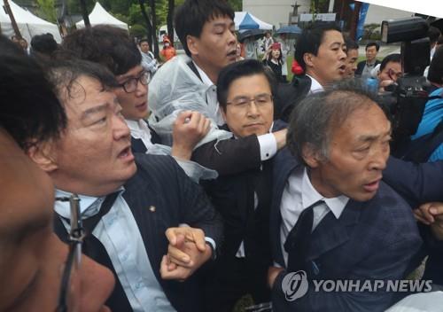 항의받는 황교안 대표 (광주=연합뉴스) 정회성 기자 = 자유한국당 황교안 대표가 18일 오전 광주 북구 국립 5·18민주묘지에서 열리는 제39주년 5·18민주화운동 기념식에 참석하려다 '망언 의원' 징계 등을 요구하는 시민에게 항의받고 있다. 2019.5.18 hs@yna.co.kr(끝)