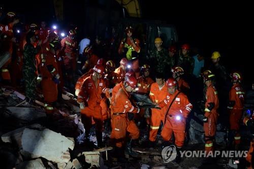 무너진 건물서 부상자 구하는 구조대