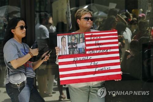 13일(현지시간) 미 시카고에서 열린 이민자 단속 항의집회에서 한 참가자가 '아이들을 석방하라'는 표지판을 들고 있다. [AFP=연합뉴스]