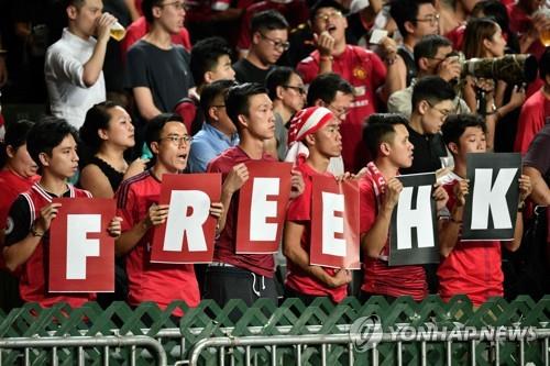 10일 홍콩과 이란 간 월드컵 축구 예선전이 열린 홍콩경기장에서 관중들이 "홍콩에 자유를"(Free HK)이라는 내용의 손팻말을 들고 서 있다.[ AFP=연합뉴스]
