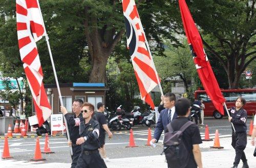 일본 패전일인 2019년 8월 15일 야스쿠니신사(靖國神社)에서 방문자가 욱일기를 들고 이동하고 있다. [연합뉴스 자료사진]