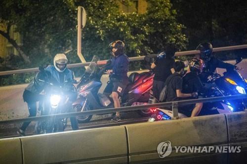 18일 밧줄을 타고 내려와 대기 중이던 오토바이를 타고 떠나는 시위대