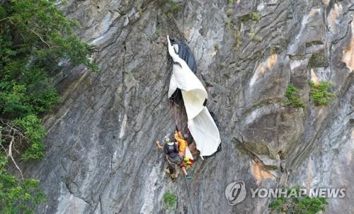 200m 높이 절벽에 5시간가량 매달려있던 베이스 점퍼(왼쪽)가 구조되는 모습
