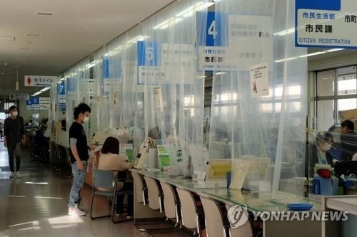 (후카야 AFP=연합뉴스) 일본 사이타마(埼玉) 현 후카야(深谷) 시청 직원들이 15일 신종 코로나바이러스 감염증(코로나19) 확산 방지를 위해 투명 가림막 뒤에서 일하고 있다. ucham1789@yna.co.kr