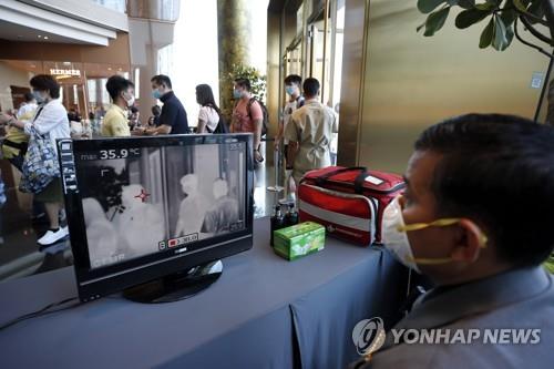 방콕 한 쇼핑몰 직원이 고객들 체온이 나타난 모니터를 보고 있다. (자료사진)