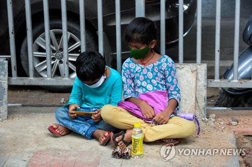 인도 하이데라바드에서 바닥에 앉아 코로나19 테스트를 기다리는 어린이들. [AFP=연합뉴스]