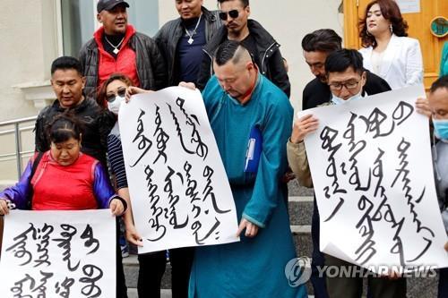 지난달 31일 몽골 울란바토르 외교부 밖에서 몽골어로 쓴 플래카드를 든 시위 참가자들이 중국에 항의하고 있다. [로이터=연합뉴스 자료사진]