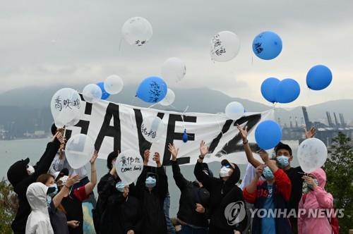 중국에 구금된 홍콩 청년활동가 12명의 가족들이 지난 21일 구금된 이들의 석방을 기원하며 중국 본토를 향해 풍선을 날려보내는 모습. [AFP=연합뉴스]